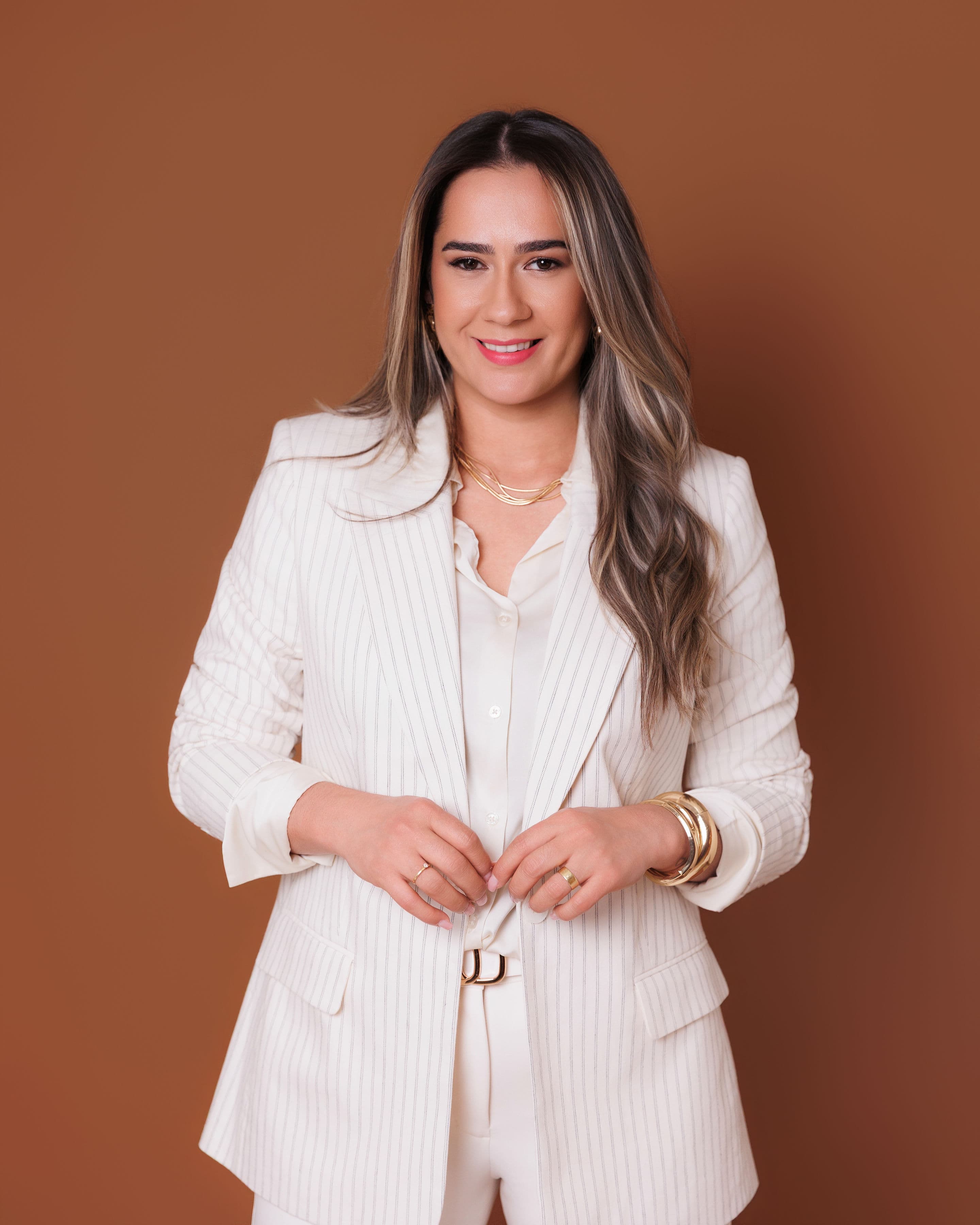 Rosângela Oliveira, fundadora da Juntas à Mesa, em blazer claro e sorriso acolhedor.