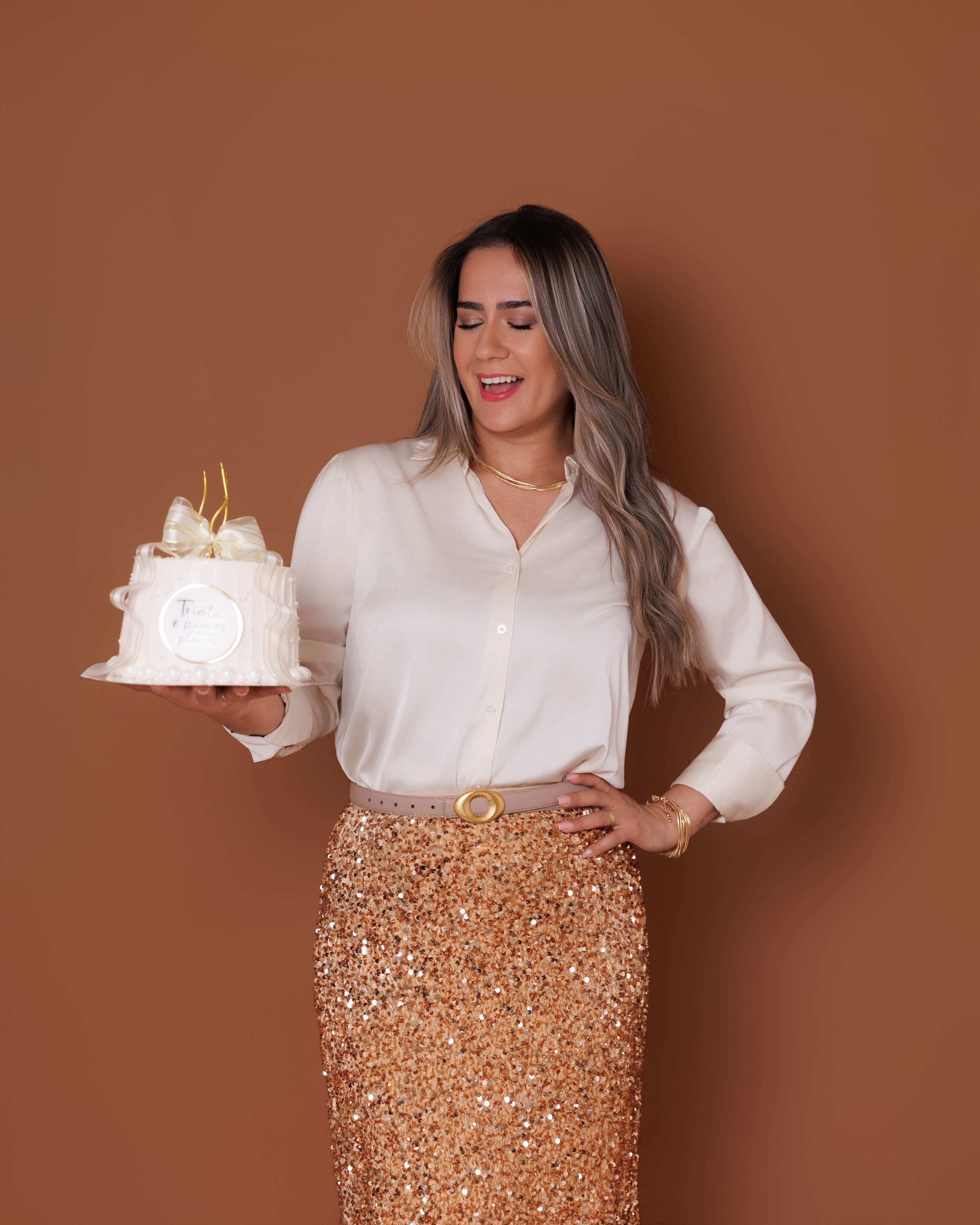 Rosângela Oliveira segurando um bolo que confeitou.